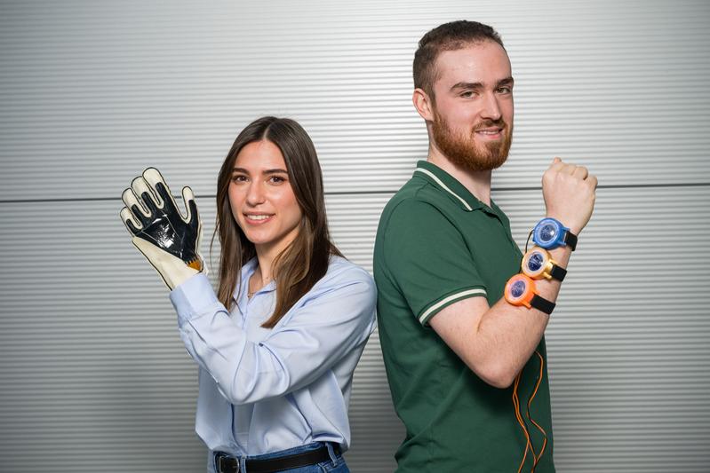 Doktorandin Sipontina Croce und Student Lukas Roth (r.) forschen an Folien, die Textilien neue Fähigkeiten verleihen. Smarte Arbeitshandschuhe werden ebenso möglich wie smarte „Uhren“, die virtuelle Berührungen spürbar machen. |